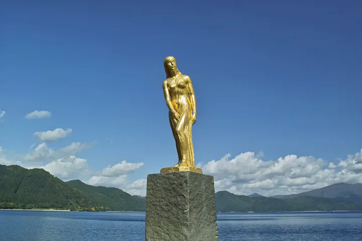 雄大な湖を背景に輝く金色のたつこ像！