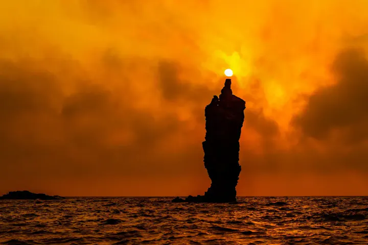 夕日が岩の先端に沈むローソク島の絶景！